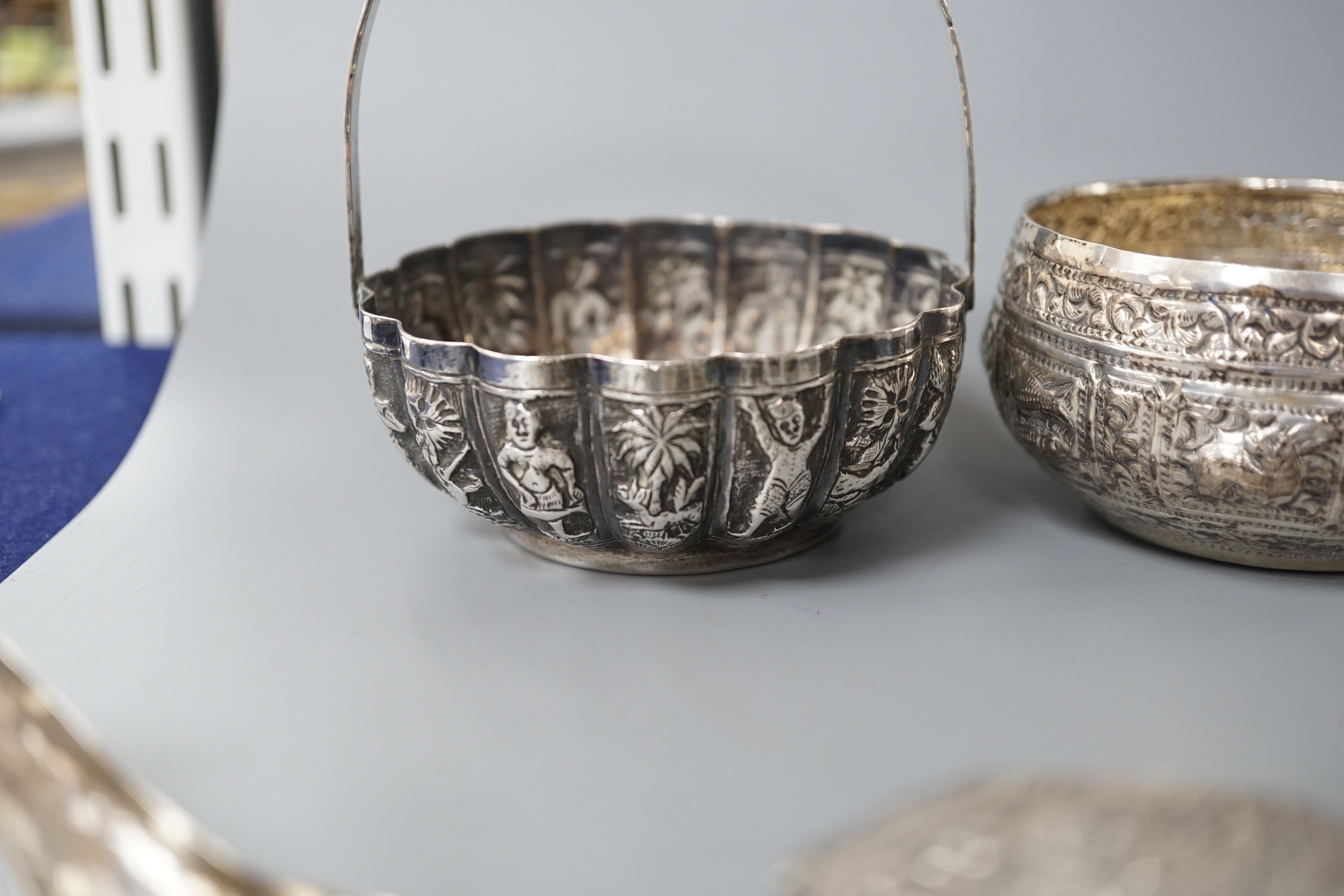 A Burmese? white metal bonbon basket, height 10.1cm and a similar bowl, two Persian white metal boxes and a spoon.